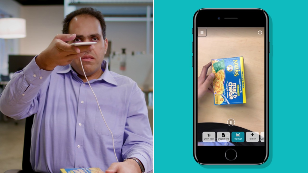 A visually impaired man in a purple shirt takes a photo of a box of mac and cheese with the Seeing AI app. 