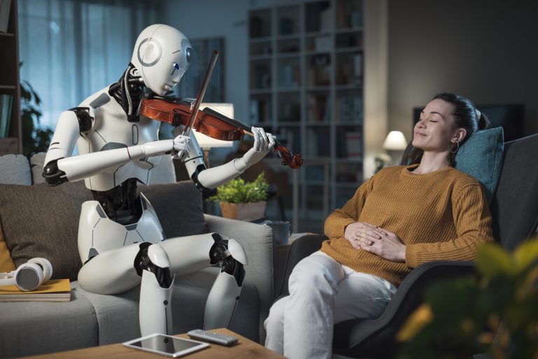 A young woman is leaning back on her chair, looking content. A robot is playing the violin for her.