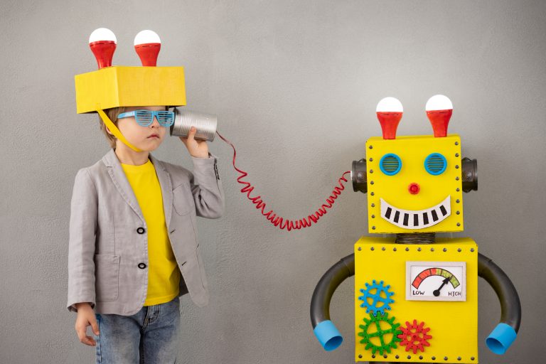 A child listening to a toy robot through a device.