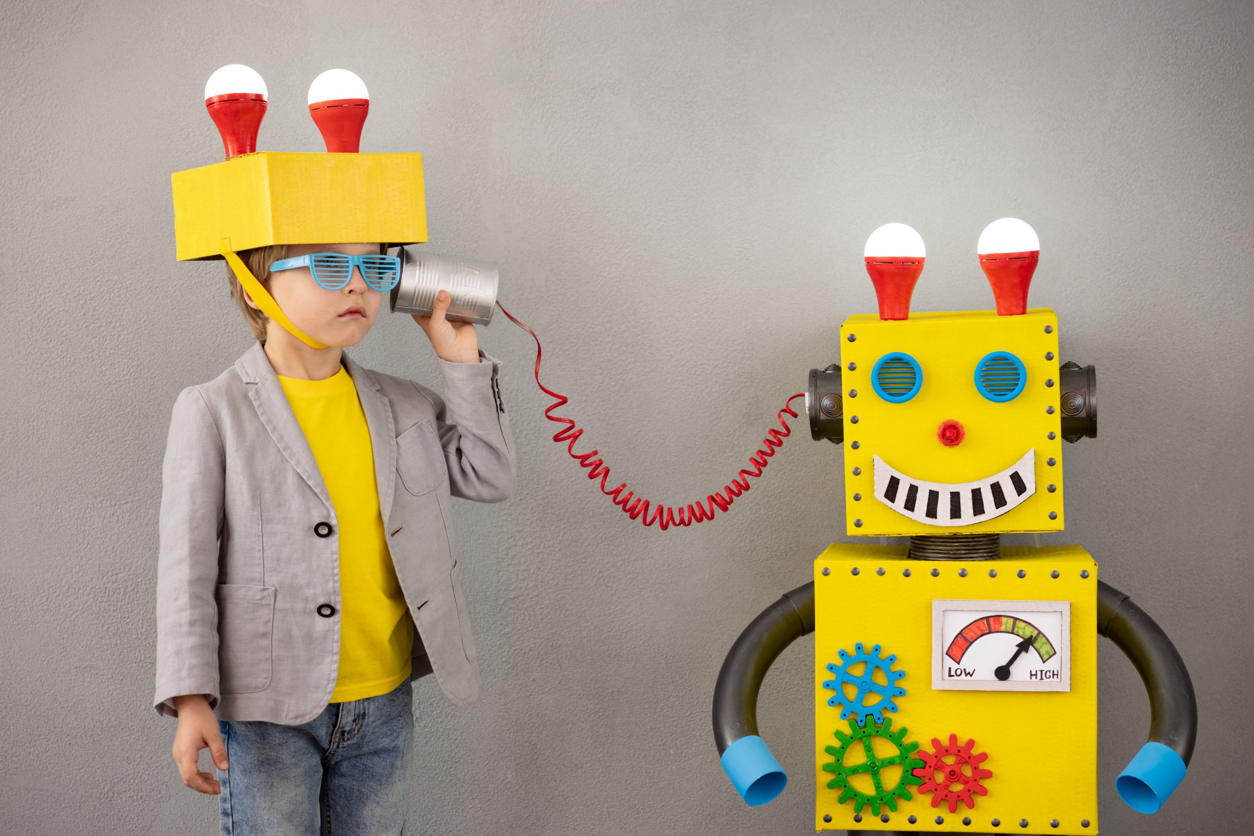 A child listening to a toy robot through a device.