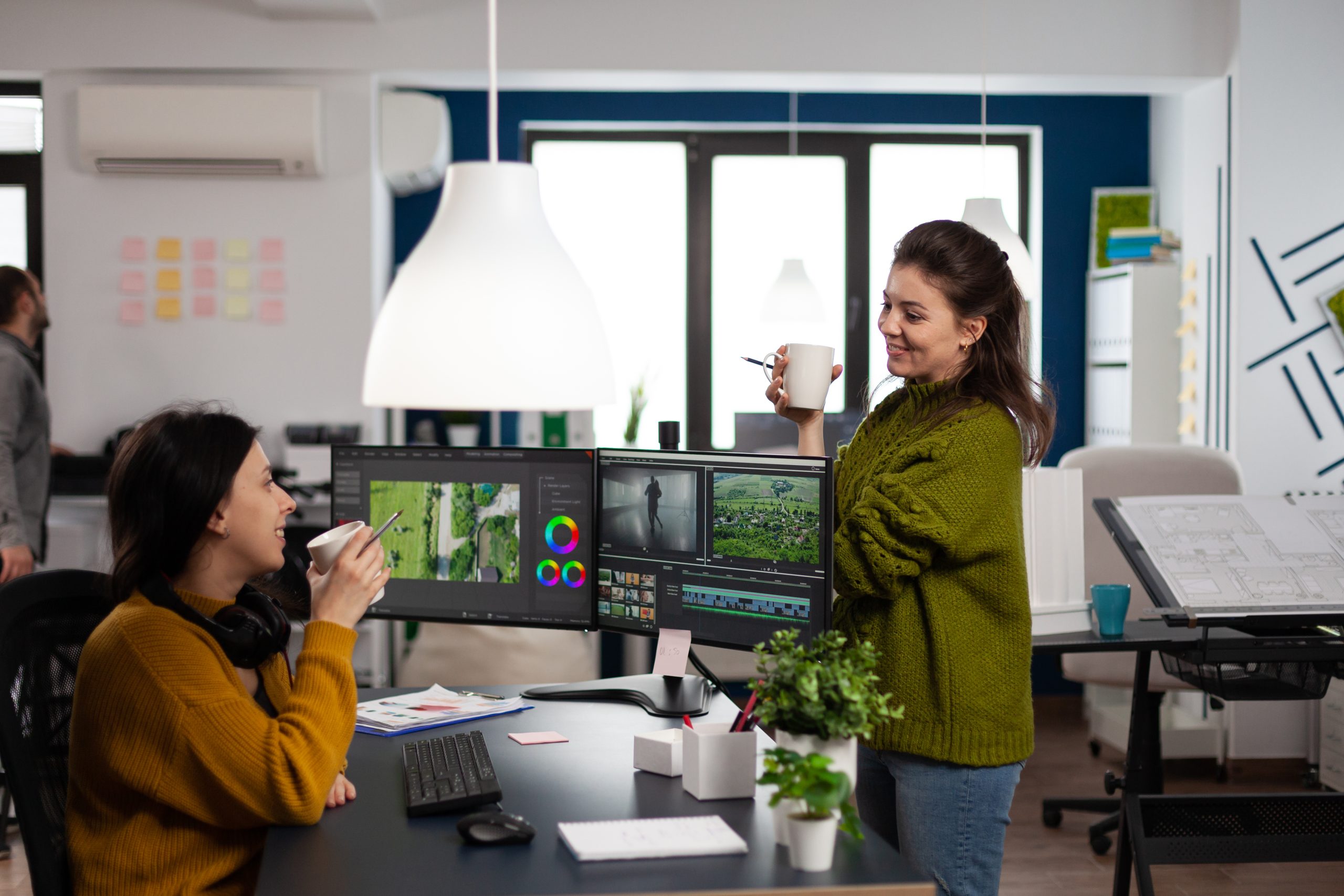 A team of content creators are sitting at a desk full of equipment.