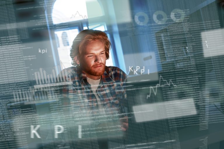 Shot of a red haired computer programmer who works on new code. He looks concentrated and thougtful. Artifitial intelligence developer