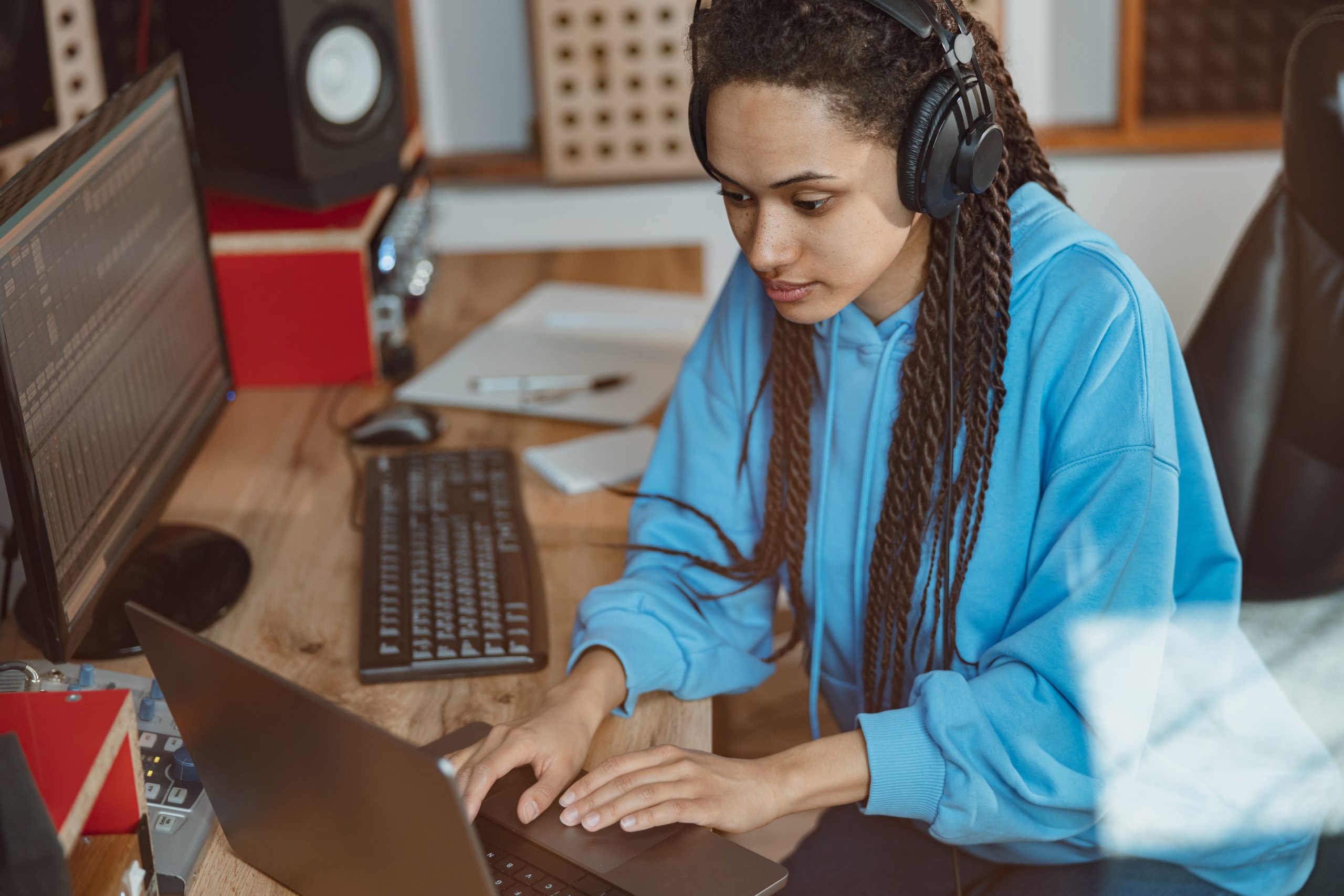 Sound engineer in headphones typing text on laptop.